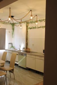 Una cocina con gabinetes blancos y una mesa y sillas. en The One Apartments, en Tăşnad