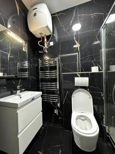 a black bathroom with a toilet and a sink at T1-Wenceslas square in Prague +11 photos