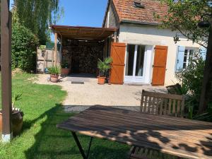 a wooden picnic table in front of a house at Studio à 15mn de Beaune in Saint-Loup-Géanges