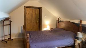a bedroom with a bed and a wooden door at Studio à 15mn de Beaune in Saint-Loup-Géanges
