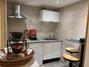 a small kitchen with white cabinets and a sink at Studio à 15mn de Beaune in Saint-Loup-Géanges