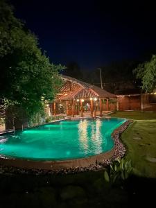 a pool of green water in a yard at night at Hera Ceylon in Nilaveli