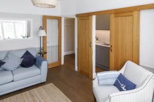 a living room with two couches and a kitchen at Grove Apartment with Free on street Parking in Worthing +20 photos