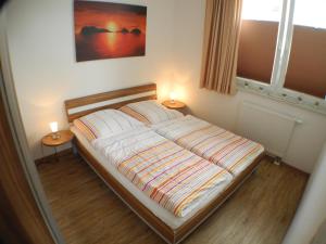 Un dormitorio con una cama con dos lámparas encima. en Strandperle 7 - Großenbrode, en Großenbrode-Kai