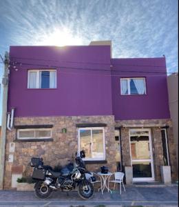 a motorcycle parked in front of a purple building at Urku Wasi Hotel in Humahuaca +16 photos