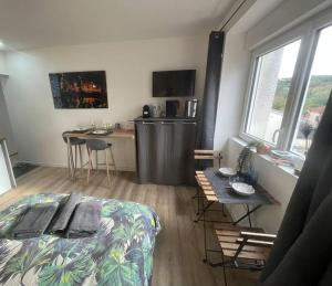 a bedroom with a bed and a table and a kitchen at VERDI studio COSY au calme parking gratuit in Chasse-sur-Rhône