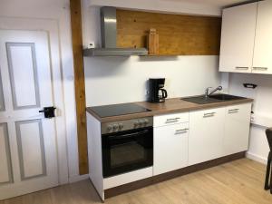 a kitchen with white cabinets and a stove top oven at Altstadthaus im Herzen Feuchtwangens in Feuchtwangen