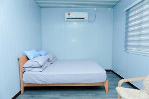 a bedroom with a bed with a blue wall at Demad Cabinstay in Jertih