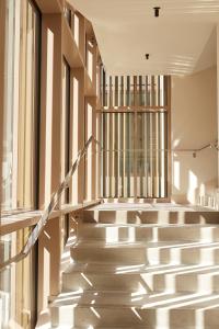 a staircase in a building with sunlight streaming through the windows at Hôtel de La Plage in Biarritz