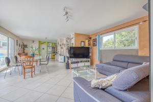 un soggiorno con un divano, una TV e un tavolo di Familiale sur 3000m2 avec piscine a Biscarrosse