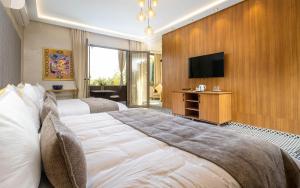 a hotel room with two beds and a flat screen tv at The Lemonary Marrakech in Marrakech