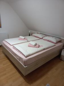 a bedroom with a bed with pink pillows on it at FAMILY HOUSE Pri Kovaču in Soča +7 photos