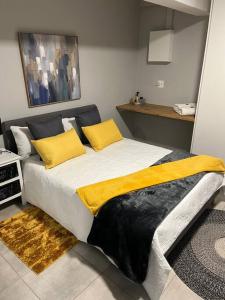 ein Schlafzimmer mit einem großen Bett mit gelben Kissen in der Unterkunft Aalwynsig in Springbok