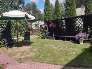 a backyard with a table and chairs and an umbrella at Pokój Sosnowa in Krasnobród