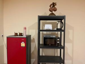 a shelf with a microwave and a red refrigerator at inghome & guesthouse in Chiang Mai