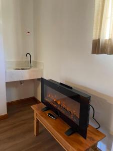a living room with a fireplace in the wall at Pousada OAK Plaza in Monte Verde +132 photos