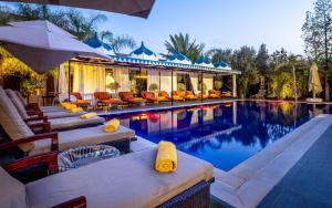 a swimming pool with chairs and an umbrella at The Lemonary Marrakech in Marrakech