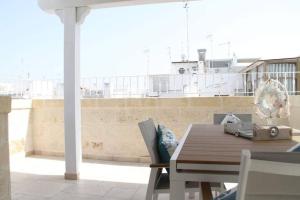 ポリニャーノ・ア・マーレにあるSogno D'Amare, casa con vista e terrazzo privatoのバルコニーにある木製のテーブルと椅子 +36枚の写真