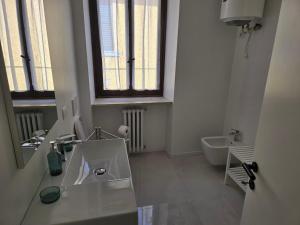 Un baño blanco con lavabo e inodoro. en La Torretta Apartment, en Peschiera del Garda 52 fotos más