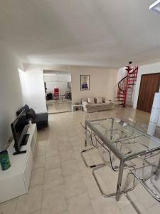 Una sala de estar con una mesa de cristal y un sofá. en La Torretta Apartment, en Peschiera del Garda