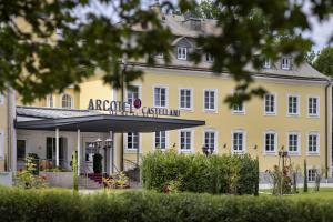 um grande edifício amarelo com uma placa que diz asilo da acrópole em ARCOTEL Castellani Salzburg em Salzburgo