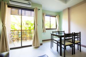 a dining room with a table and chairs and a window at Banlanna Hotel Lampang in Lampang