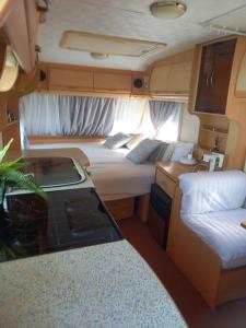 a room with two beds and a kitchen in an rv at Acogedor y tranquilo in Marratxí 