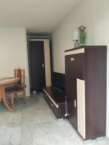 a living room with a tv and a table and a chair at Pokój dwuosobowy Sosnowa in Krasnobród