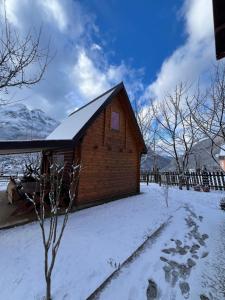 a small wooden cabin with snow on the ground at Guest House Kollata in Vusanje