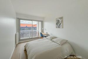 a white bedroom with a bed and a window at Flexliving - room - Clichy la Garenne in Clichy