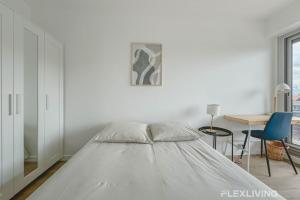 a white bedroom with a bed and a table at Flexliving - room - Clichy-la-Garenne in Clichy