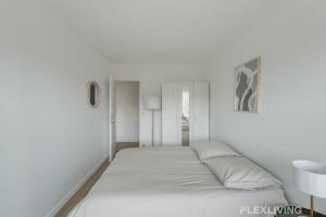 a white bedroom with a large bed in it at Flexliving - room - Clichy-la-Garenne in Clichy +11 photos