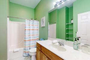 a bathroom with green walls and a sink and a toilet at Village of Five Points --- 33322 E Chesapeake St UNIT 46 in Lewes +16 photos
