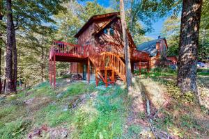 a log cabin in the woods with a large deck at Chestnut Hill Hideaway in Lake Ariel