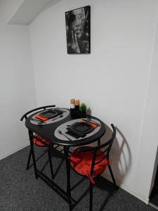 einen schwarzen Tisch mit einem roten Stuhl in einem Zimmer in der Unterkunft Amore 2 in Timişoara
