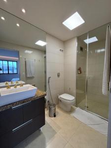 a bathroom with a sink and a toilet and a shower at Apart Hotel Moderno em Joinville in Joinville