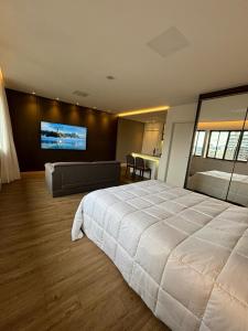 a bedroom with a large bed and a flat screen tv at Apart Hotel Moderno em Joinville in Joinville +26 photos