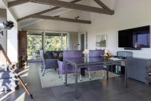 a living room with a table and purple chairs at OV573 - Luxurious, modern holiday villa for 11 people on the water near Giethoorn in Blokzijl