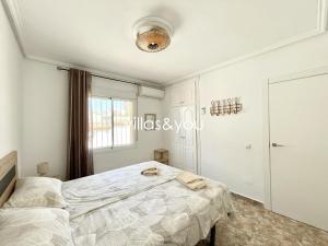 ein weißes Schlafzimmer mit einem Bett und einem Fenster in der Unterkunft Villa Palmera Ciudad Quesada by Villas&You in Rojales + 27 Fotos