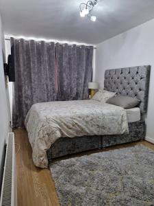 a bedroom with a bed with a gray headboard at Heronsgate GH018 in Kent