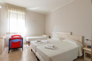 ein Hotelzimmer mit zwei Betten und ein roter Rucksack in der Unterkunft Hotel Classicano in Ravenna