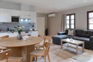 a kitchen and living room with a table and a couch at Visulahti Cottages in Mikkeli