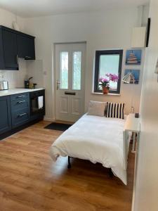 a bedroom with a bed and a kitchen at Marta Studio Apartment in Ennistymon