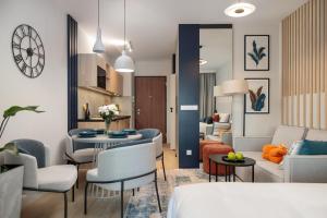 a living room with a couch and a table and chairs at Baltic Waves Resort by PI Apartments - Official Operator in Międzyzdroje