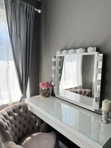 a mirror sitting on top of a glass table at Brother street apartment in Liepāja +10 photos