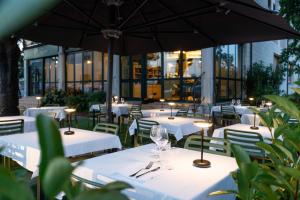 ein Restaurant mit weißen Tischen und Stühlen und einem Sonnenschirm in der Unterkunft Hotel Classicano in Ravenna