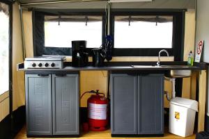 a kitchen with a counter and a fire hydrant under a sink at Mietwohnwagen in Hörnum