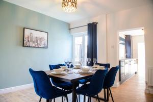 a dining room with a table and blue chairs at Stunning House - Sleeps 7 - 5 Mins walk to Lincoln High Street - Parking - Wifi in Lincolnshire