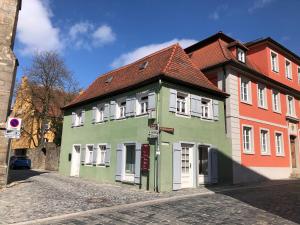 a green building with white windows on a street at Altstadthaus im Herzen Feuchtwangens in Feuchtwangen