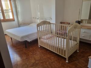a bedroom with two cribs and a bed in a room at "Domus Cannas"-Casa Indipendente- in Cagliari +5 photos